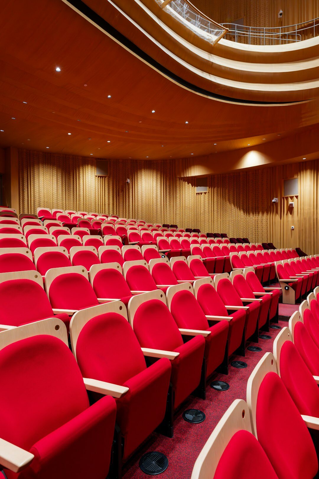 Empty theater auditorium with red seats and stage lights